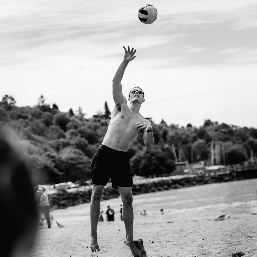 Connor jumping to hit a volleyball on the beach