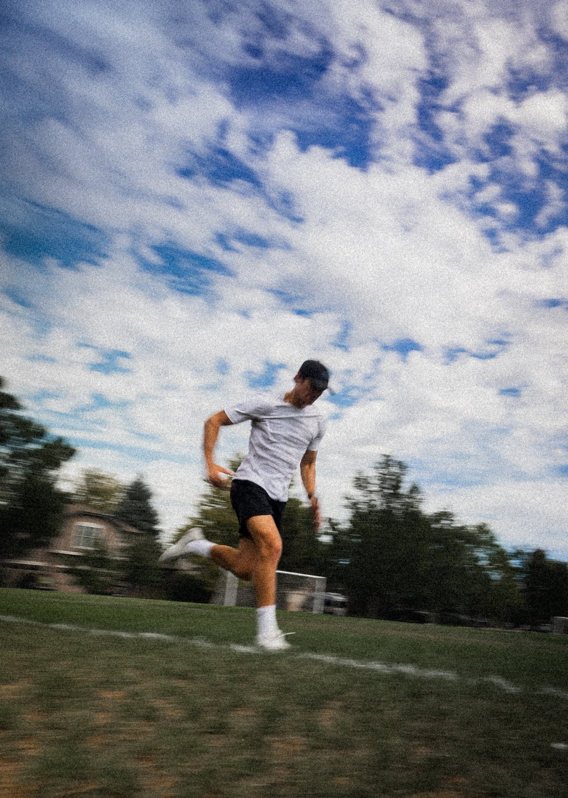 Connor sprinting across a field under a blue sky, panned motion blur