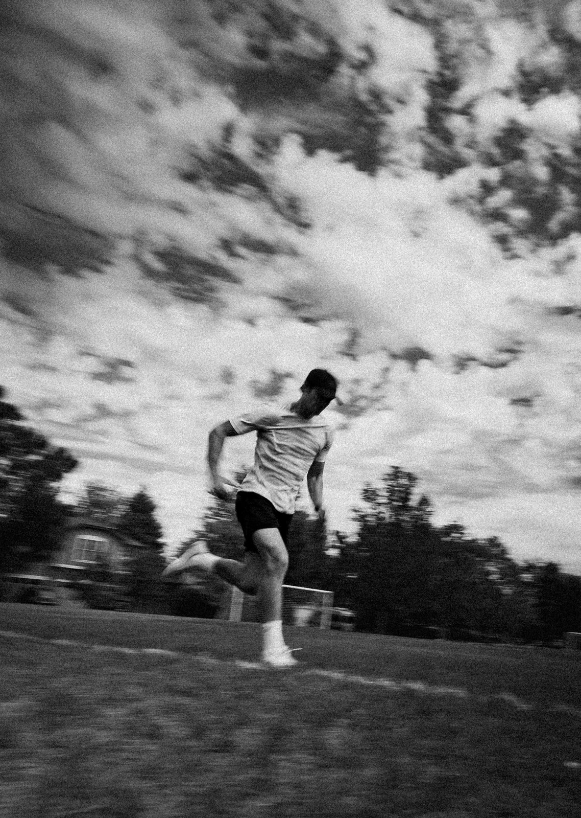 Connor running across a field, black and white, panned motion blur