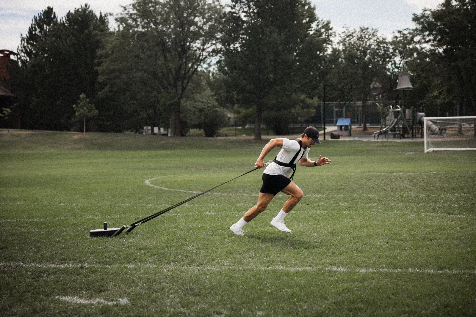 Connor sprinting with a sled on a field