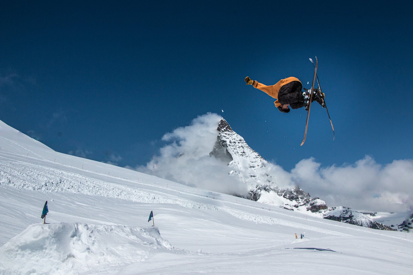 Connor upside down on skis with the Matterhorn behind him